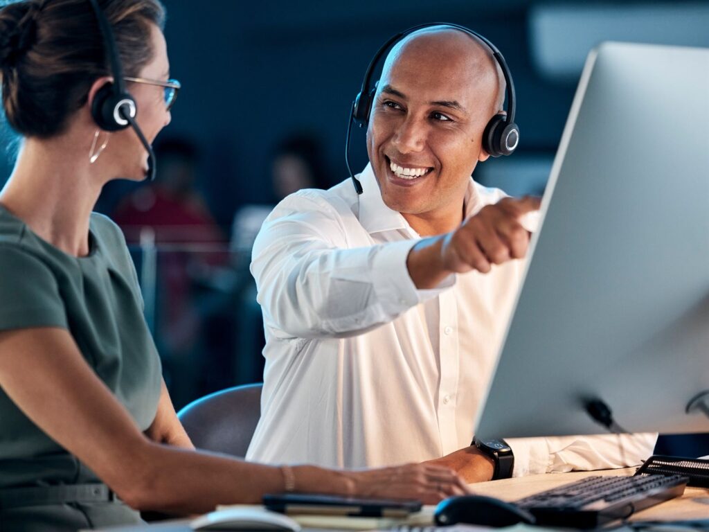IT engineer helping a colleague with a laptop